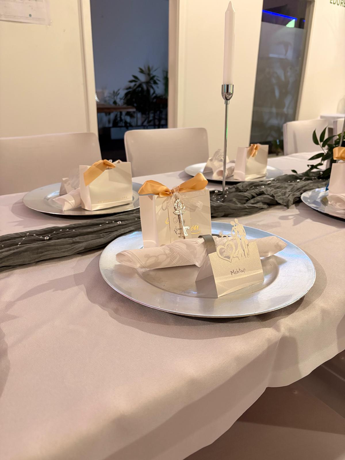 Festliches Gedeck mit persönlichem Gastgeschenk und goldener Schleife