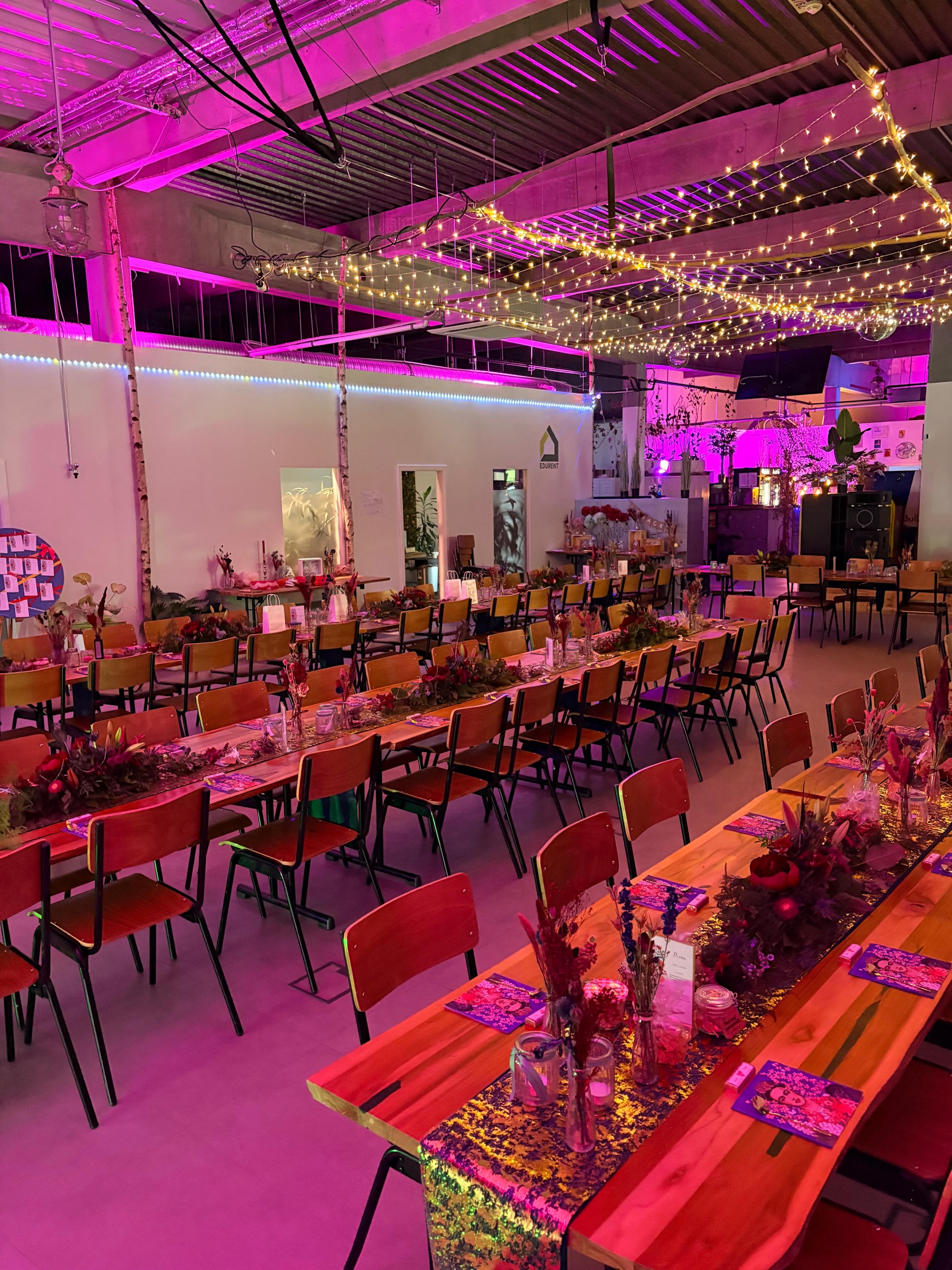 Festsaal mit rustikalen Holztischen, eleganter Tischdekoration und festlicher Beleuchtung